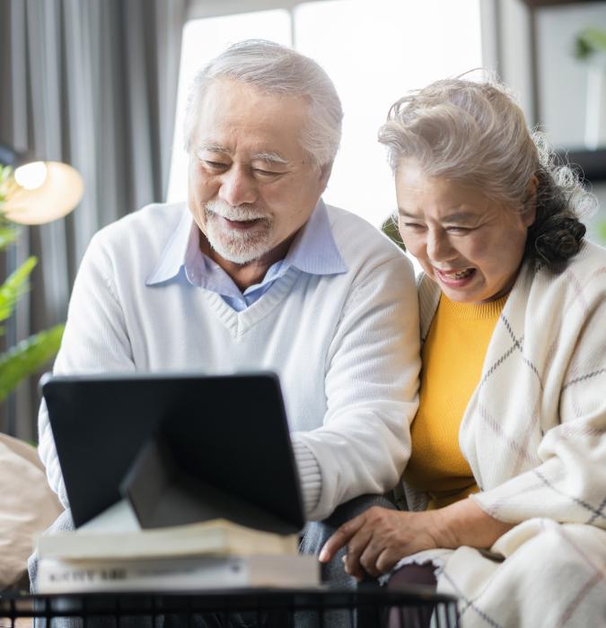  Senior couple retired age sitting at computer making donation