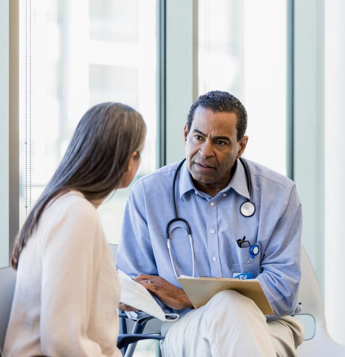 Adult male doctor having a medical consultation with a woman