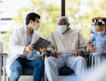 Caregiver masked at primary care visit with grandparent and grandchild 
