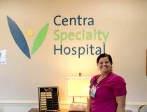 Caregiver standing in front of Centra Speciality Hospital sign