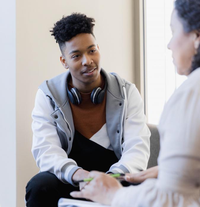 A teen speaks with a counselor. 
